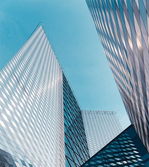 Two towering buildings seen from ground level, reaching towards the sky.