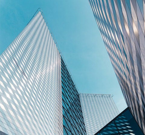 Two towering buildings seen from ground level, reaching towards the sky.