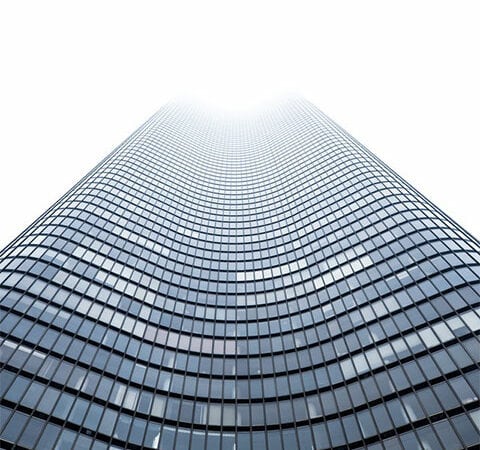 A towering building with numerous windows, offering a captivating view of urban architecture.